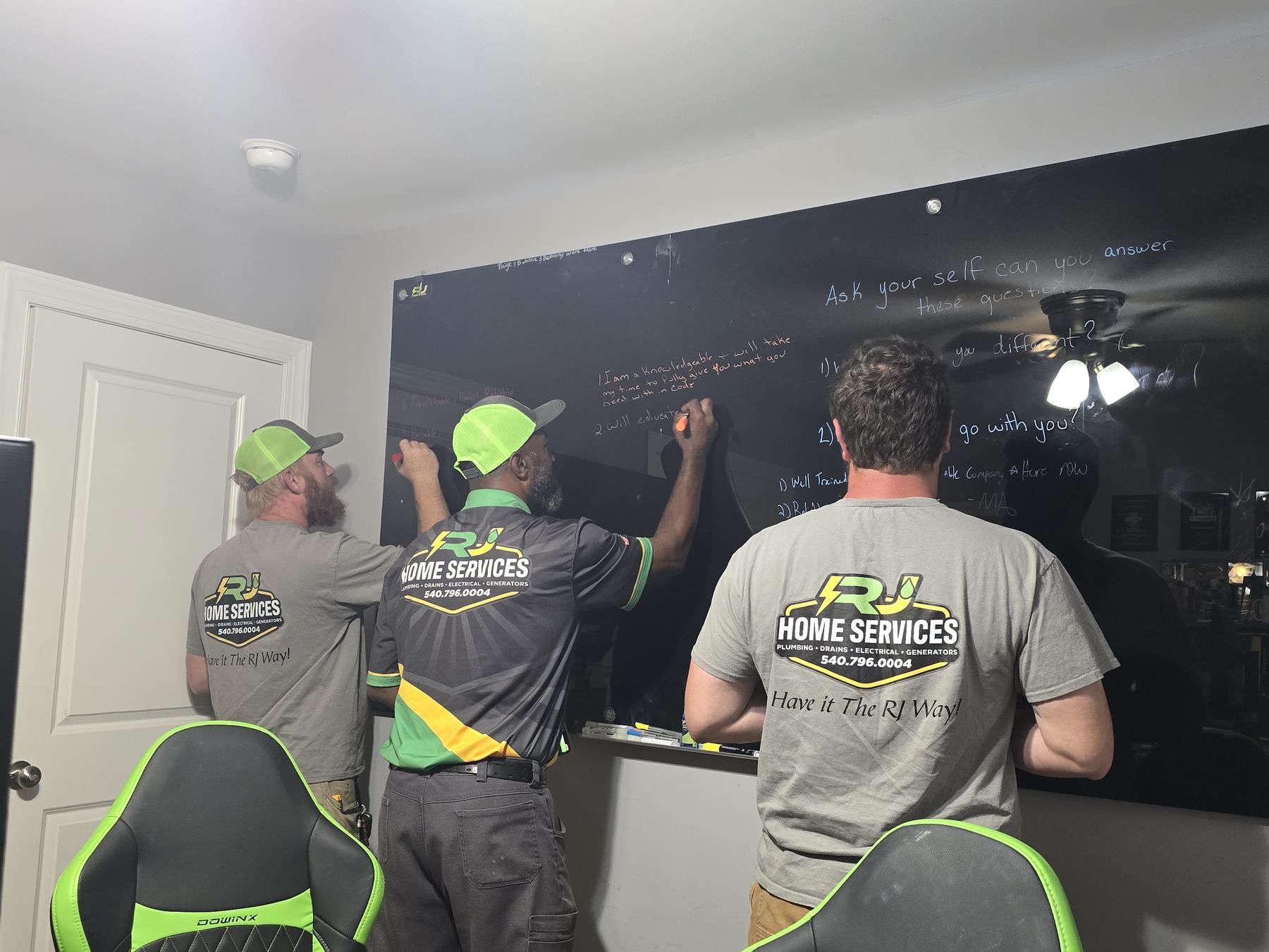 RJ technicians planning at a whiteboard in the Goldvein office